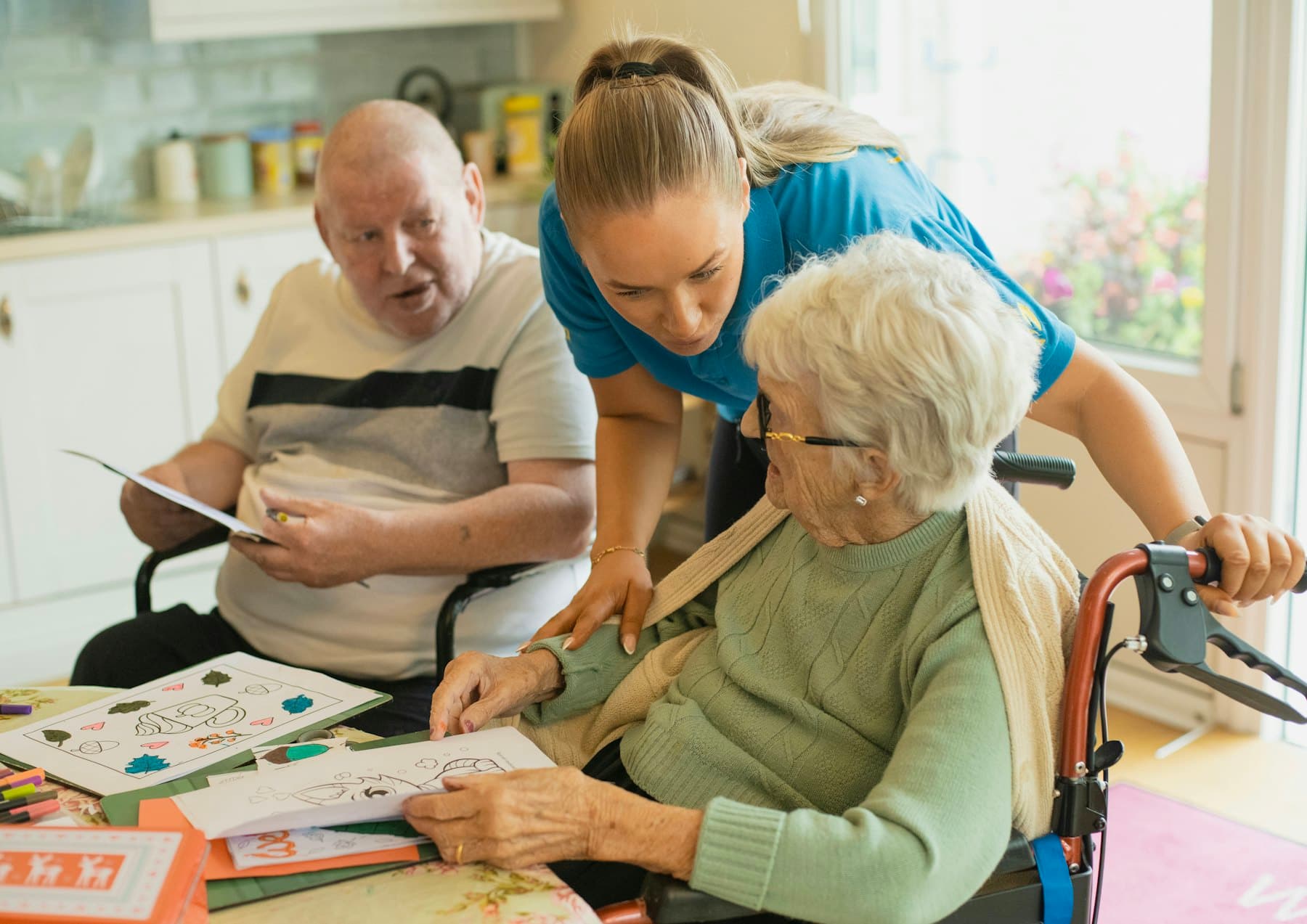 A caregiver coloring with an older couple