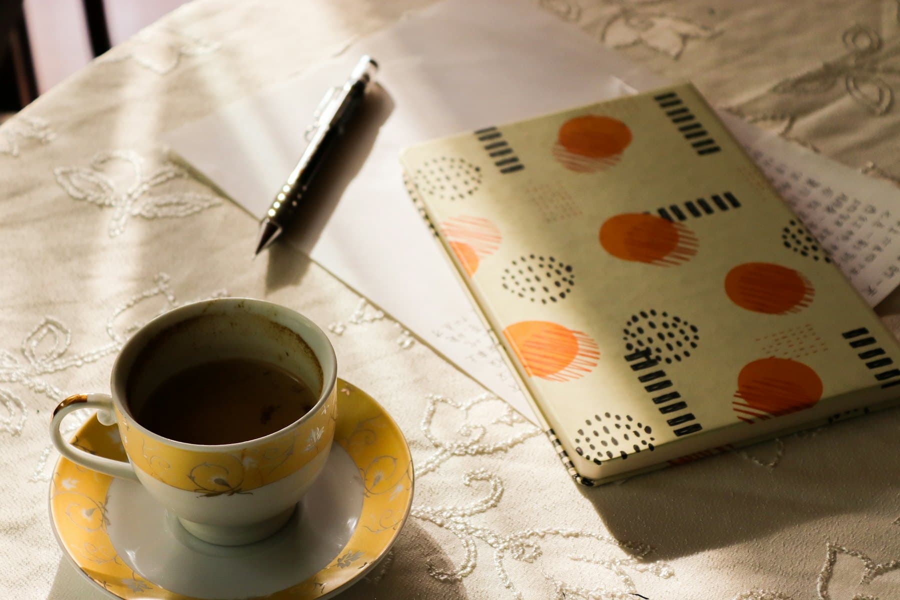 A cup of coffee and a notebook on a table