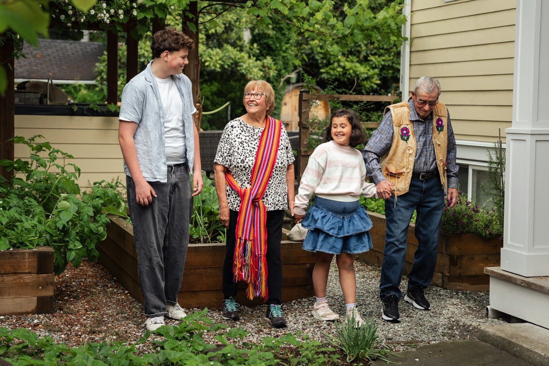 A family of four walking together in a garden