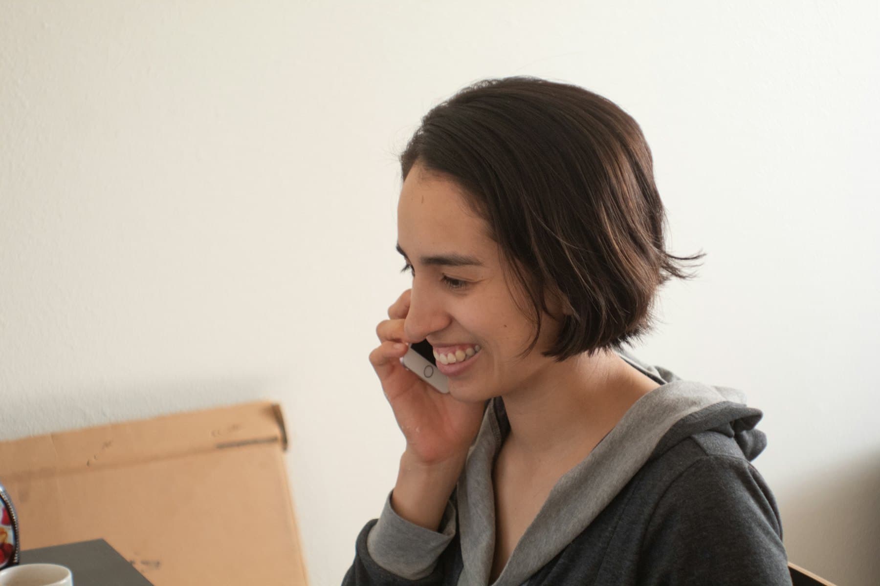 A smiling woman in a gray hoodie