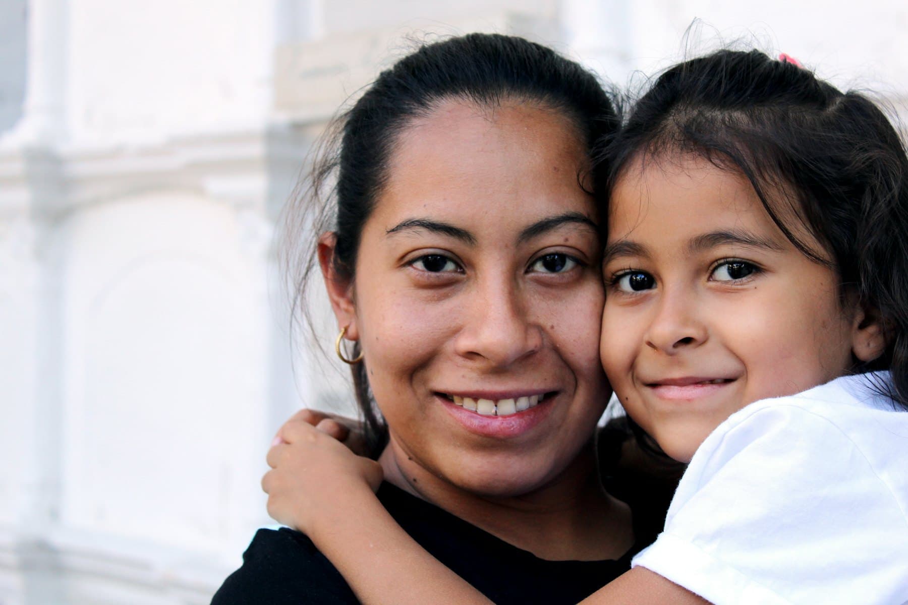 A woman and a child smiling in a close embrace