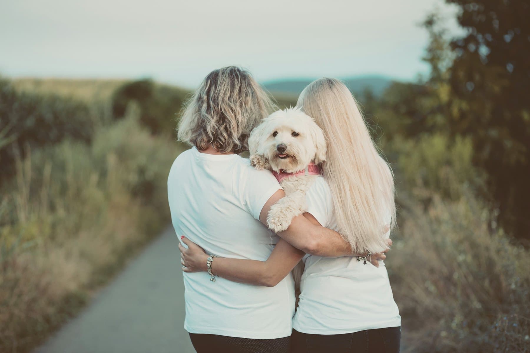A woman hugging her white dog