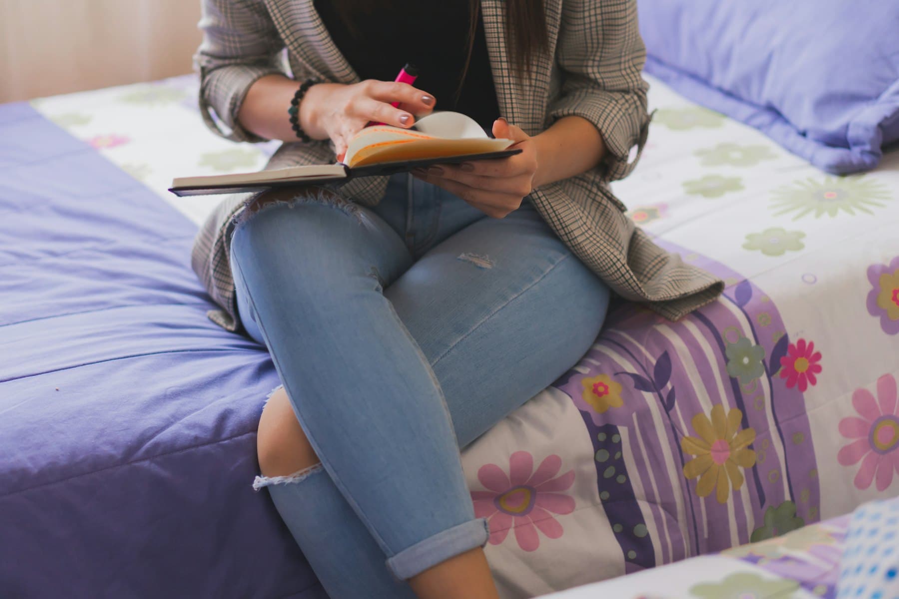 A woman in a cardigan sitting on a floral couch