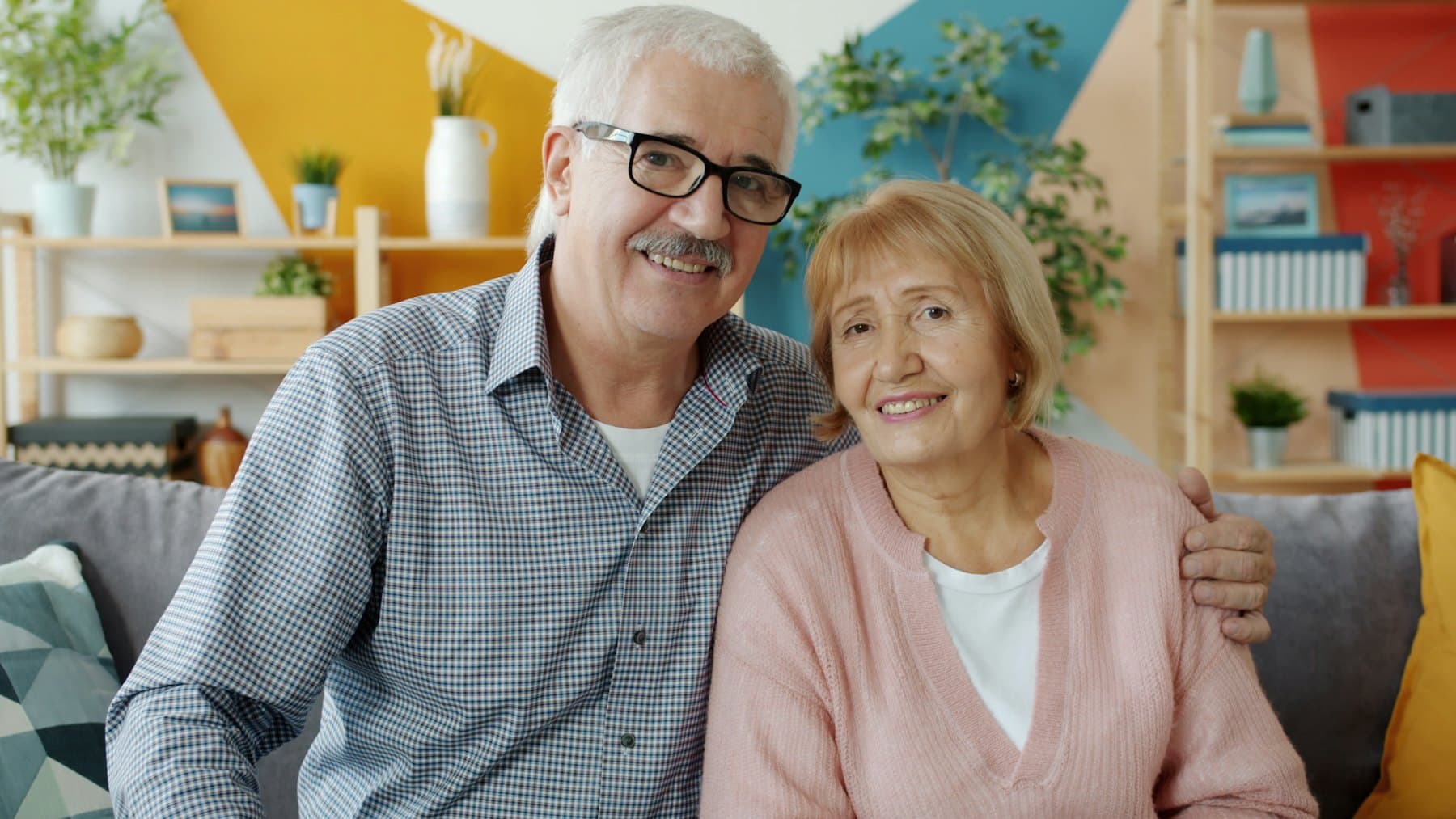 An older couple smiling together on a couch