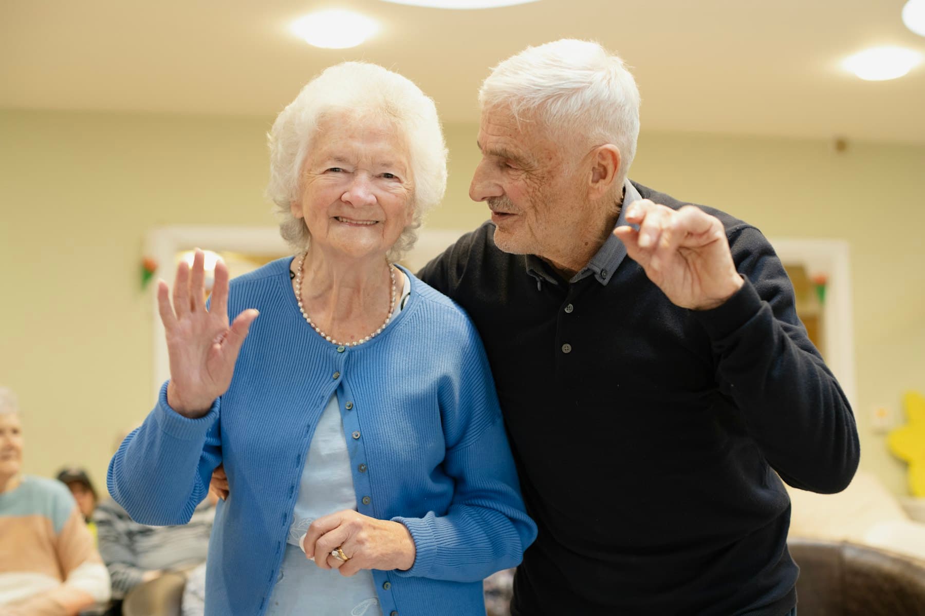 An older couple waving hello