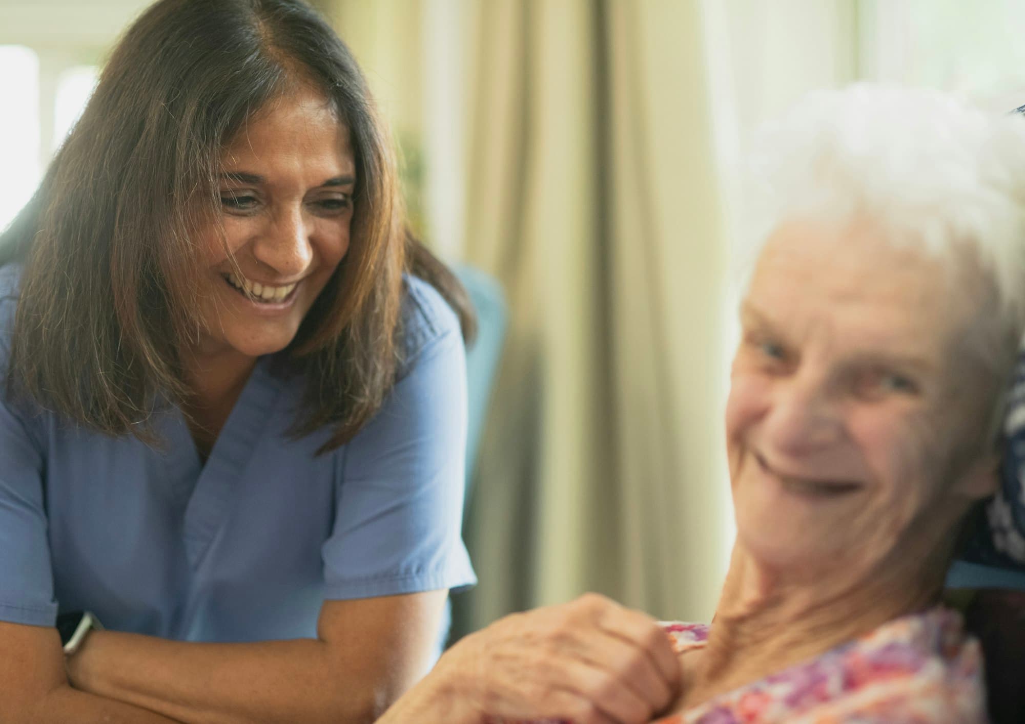 A caregiver smiling with an older woman