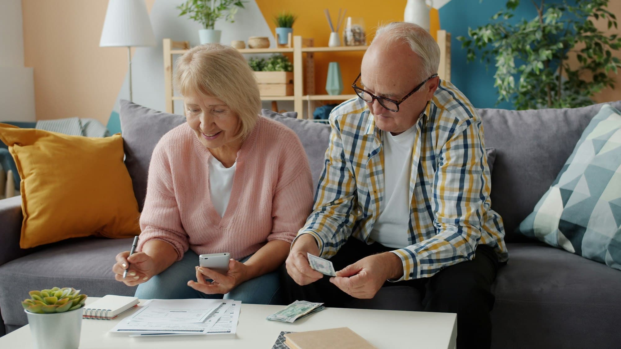 An older couple sorting bills together at home