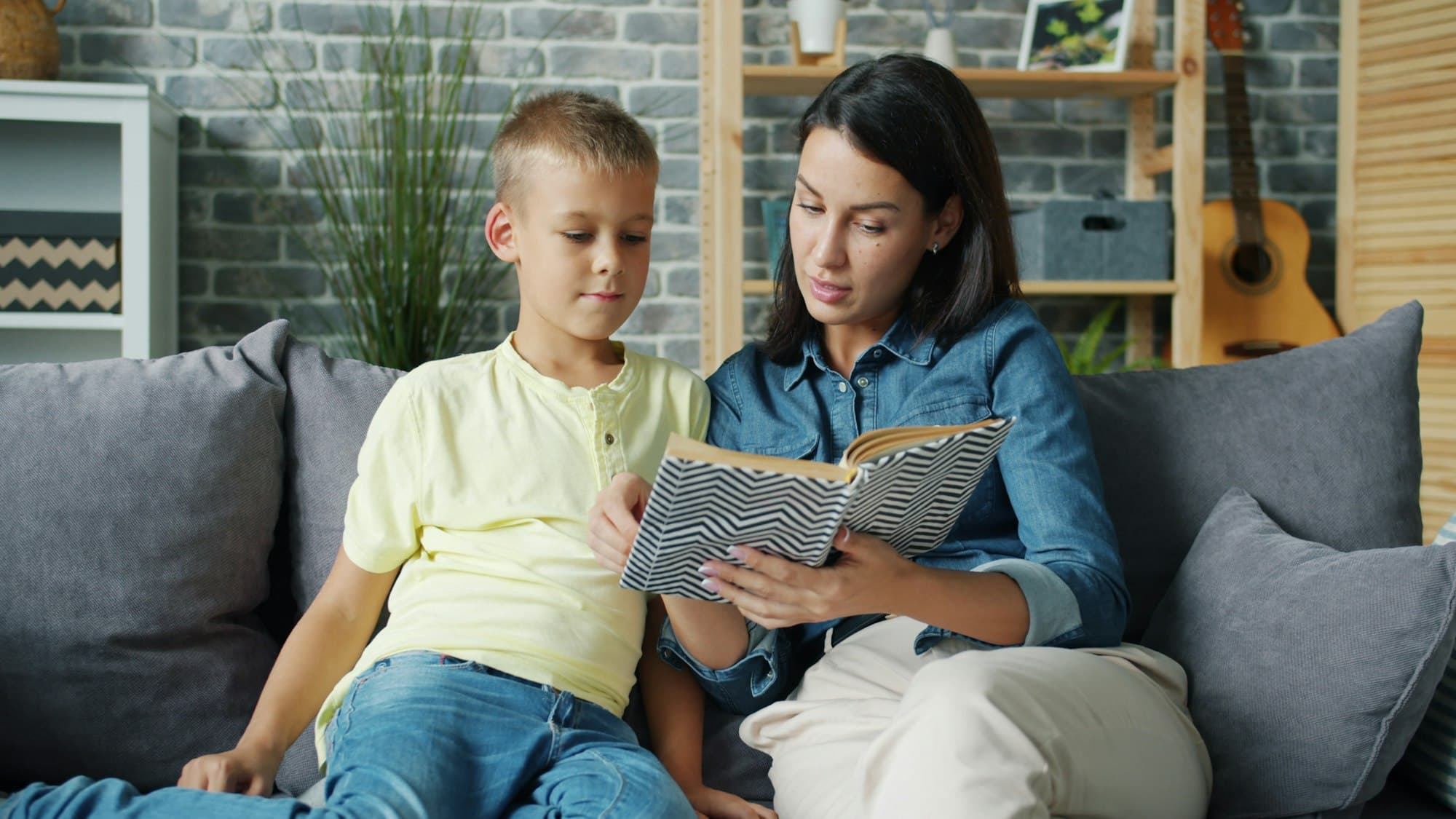 A mother and her son reading together at home