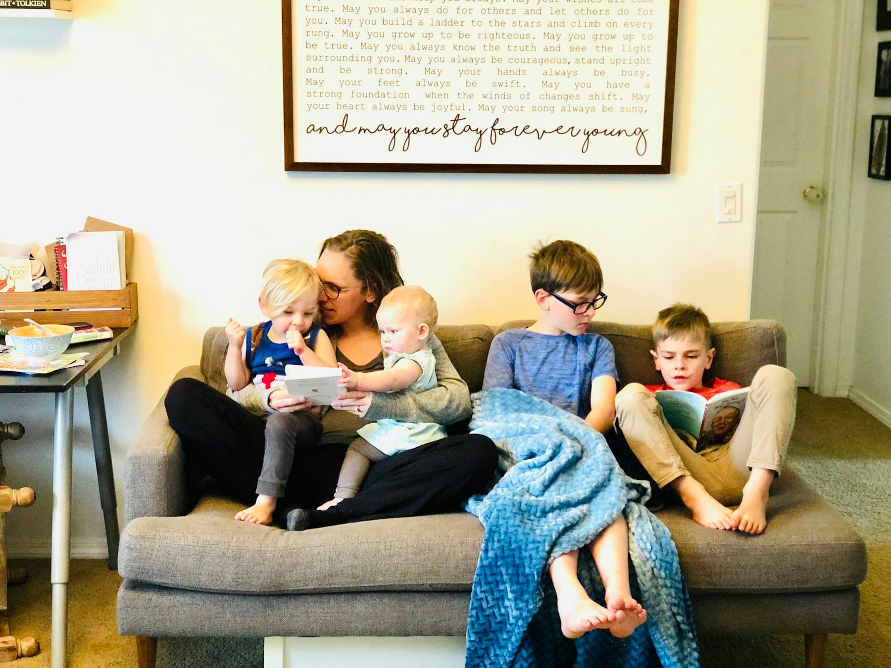 Three children sitting on a gray couch