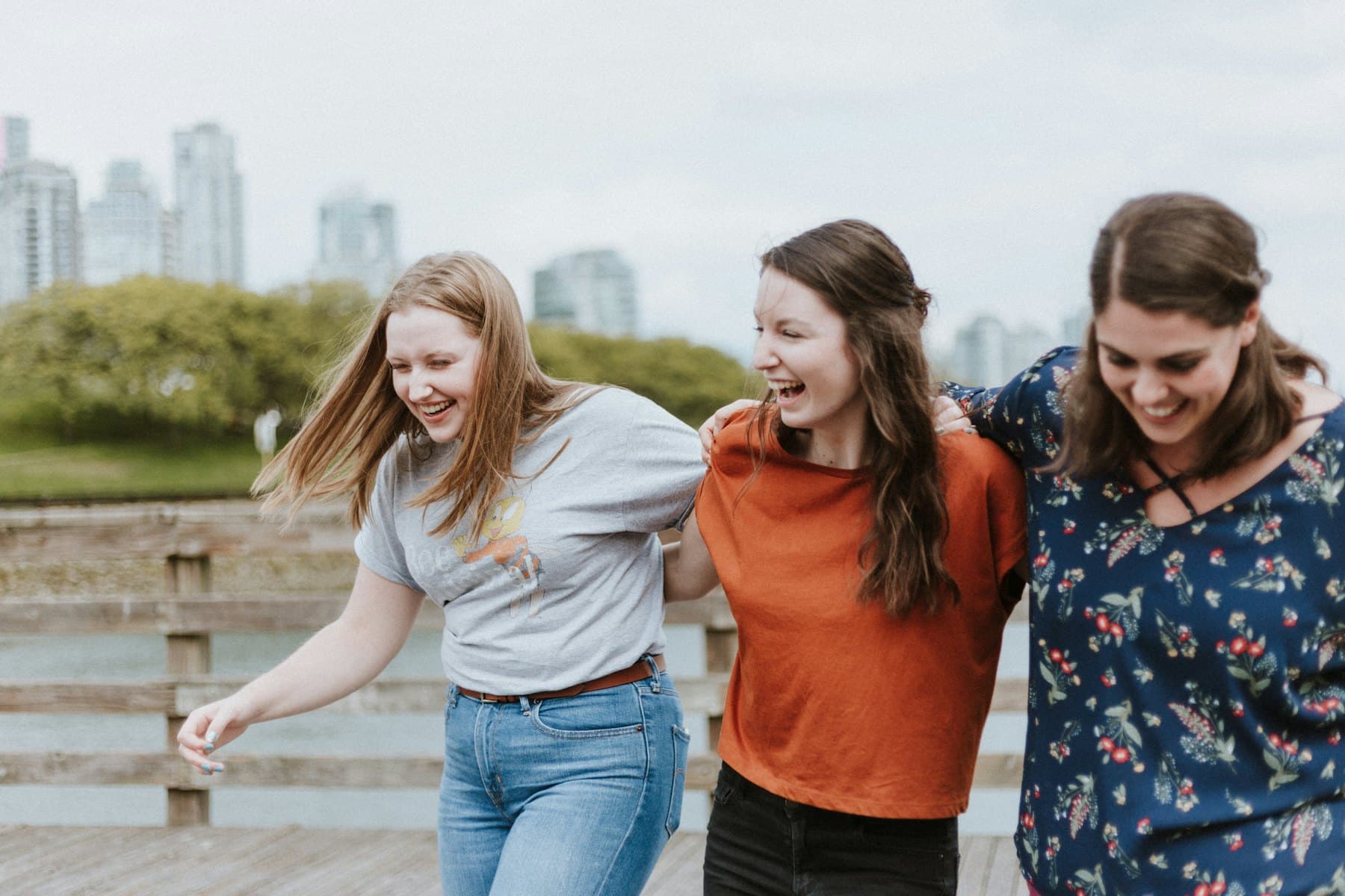 Three women walking on a wooden dock