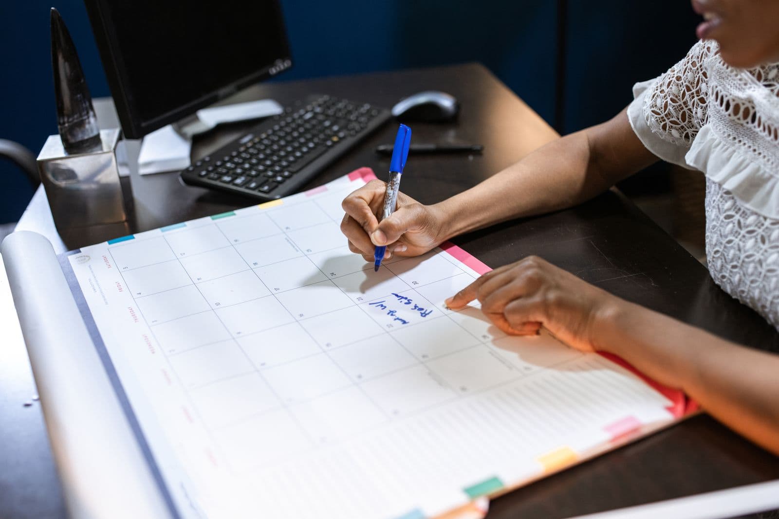 A person marking dates on a large desk calendar, the way families track upcoming FDA decision days.