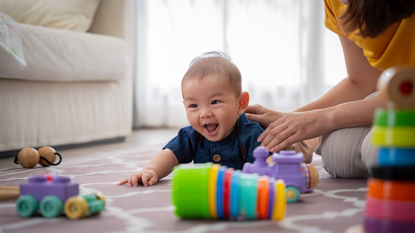 Happy baby playing with colorful toys, representing hope for children with ultra-rare diseases