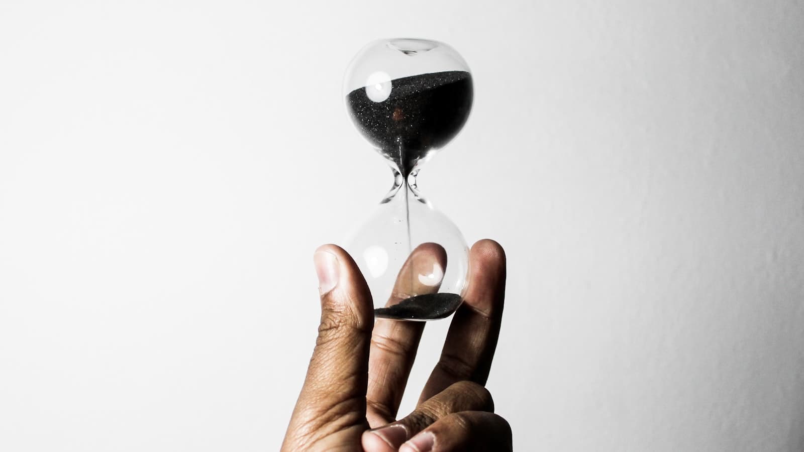 A hand holds an hourglass with sand running through it, marking the final weeks before 8 rare disease FDA decisions in September 2026.