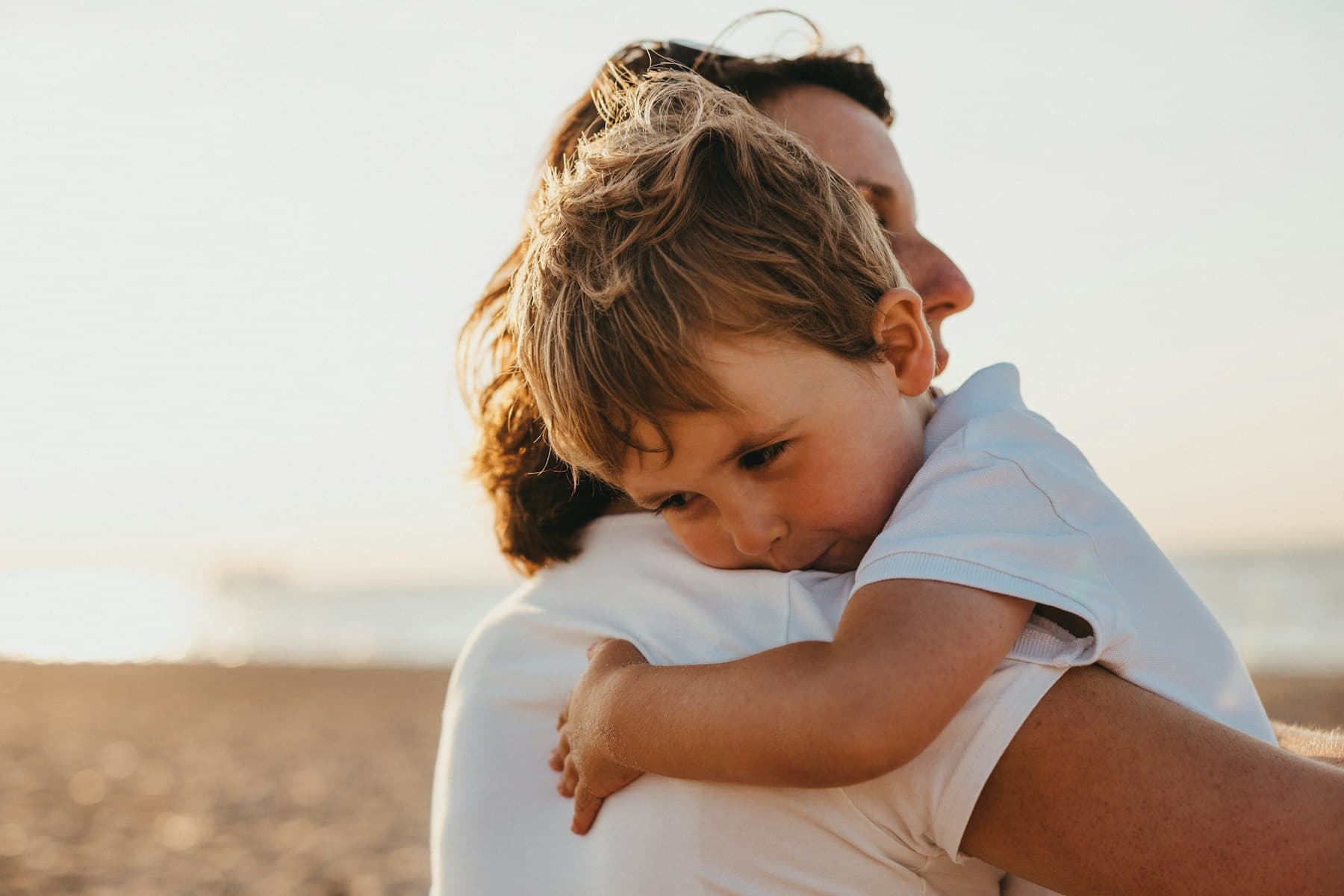 A boy hugging a woman outdoors