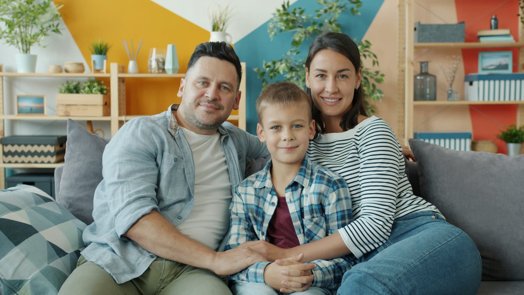 A family of three sitting together on a couch
