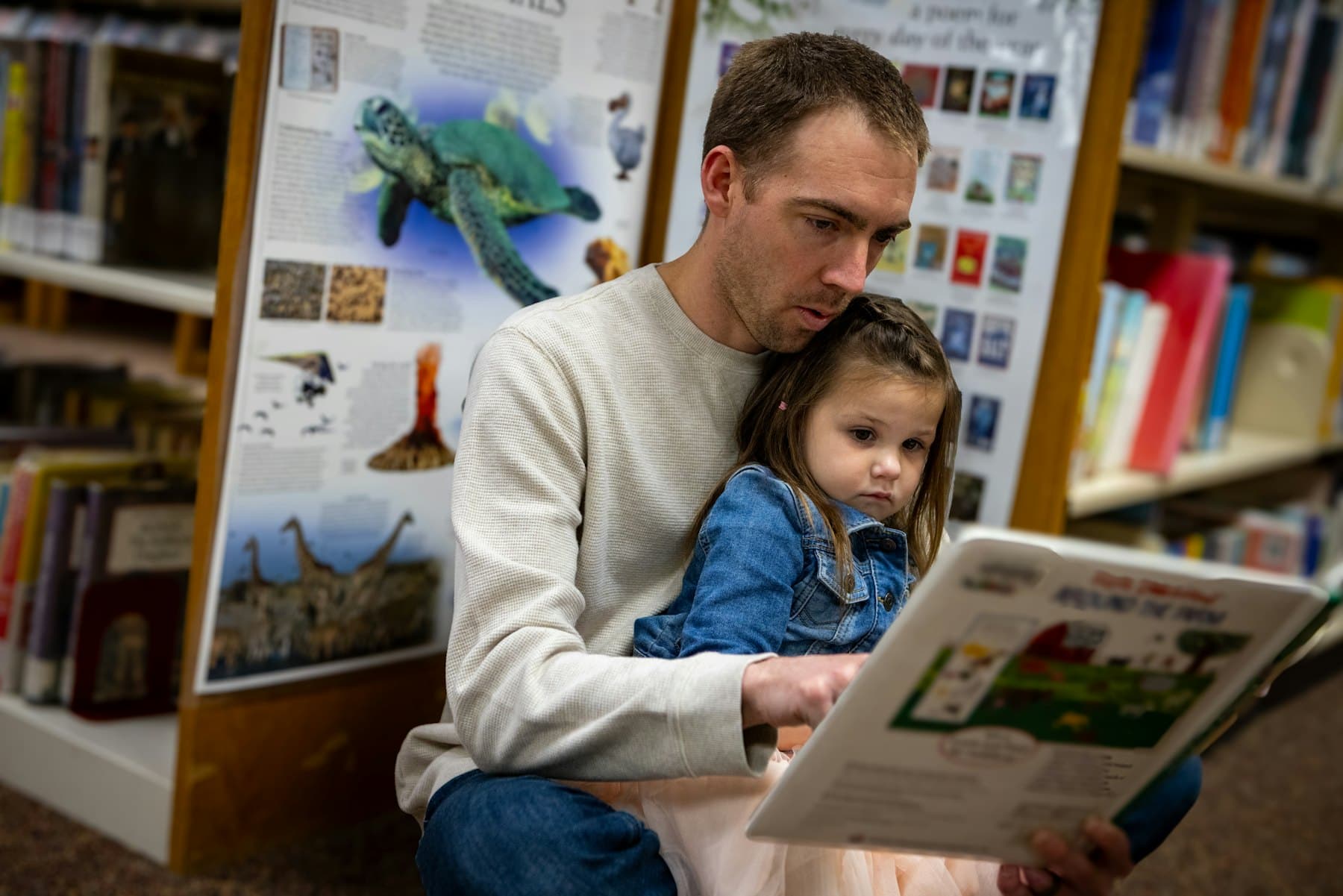 A father and daughter reading a book together