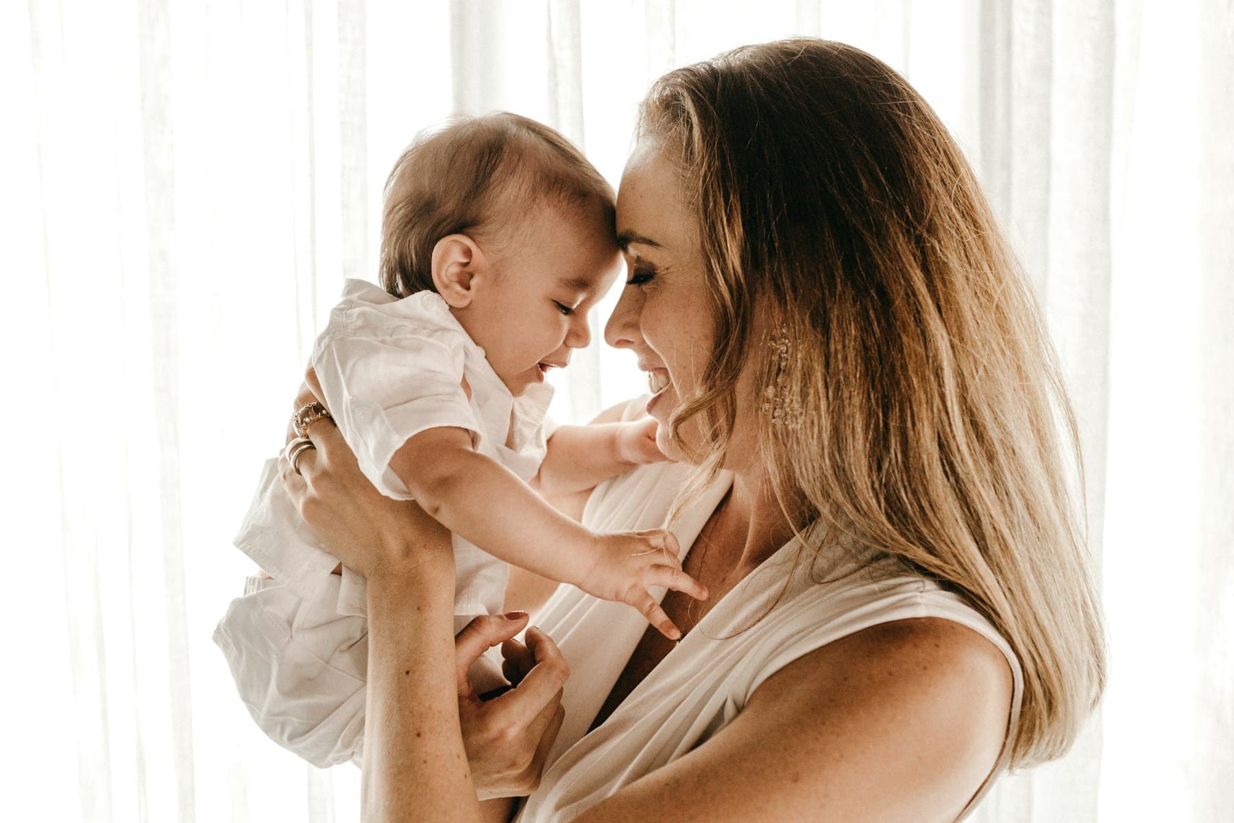 A smiling woman carrying a baby