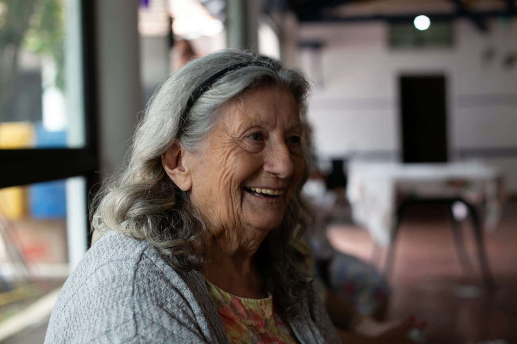 A smiling woman in a gray cardigan
