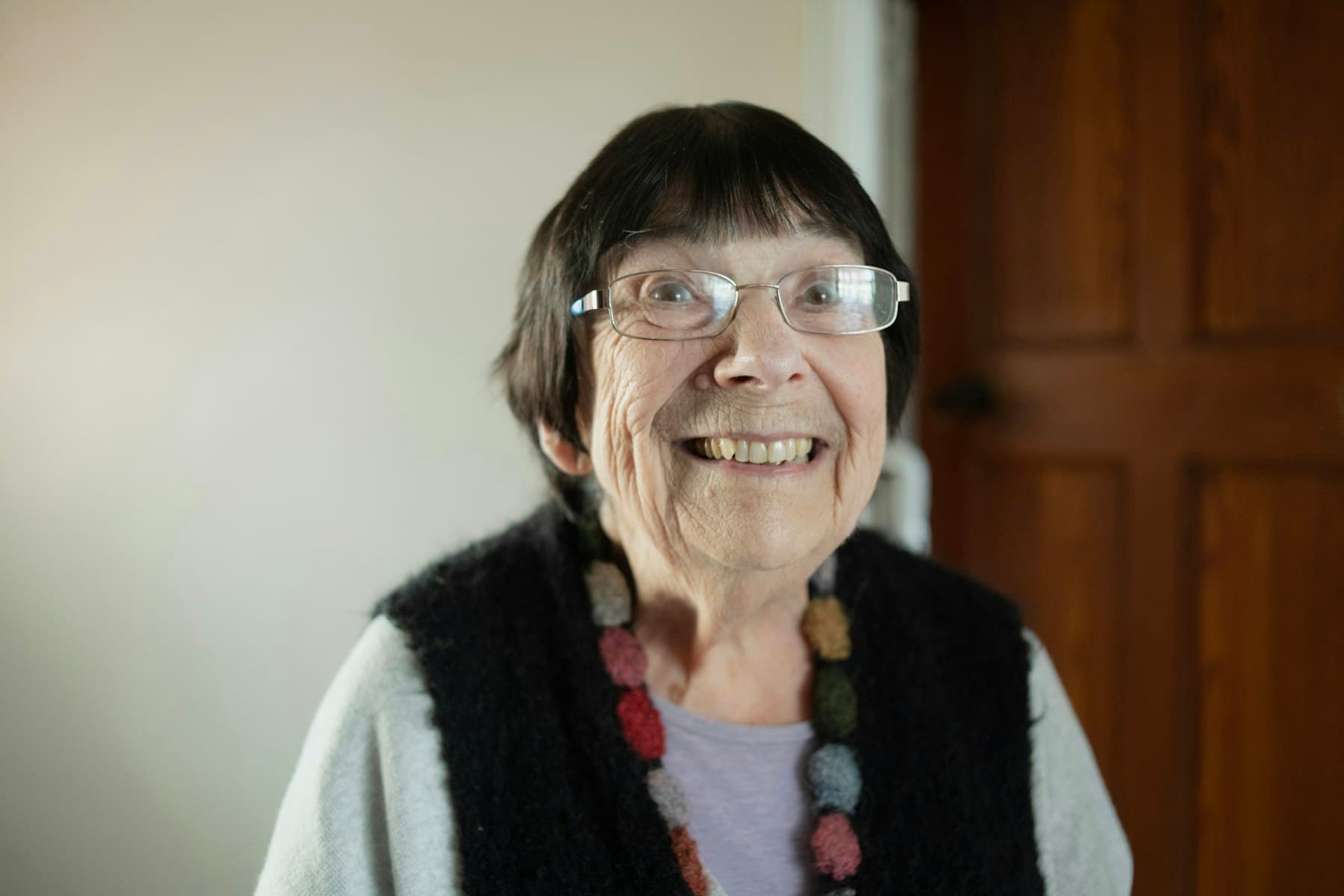 An older woman in glasses and a necklace