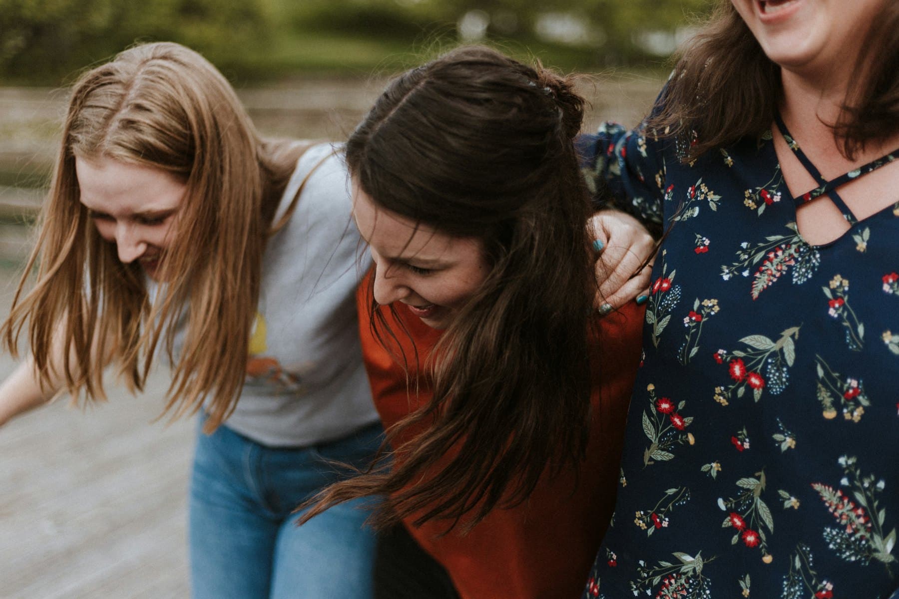 Three women holding each other and smiling